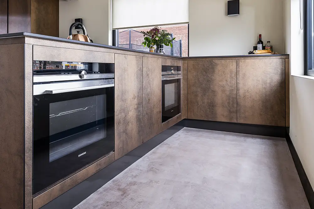 een bruine keuken met inbouw oven